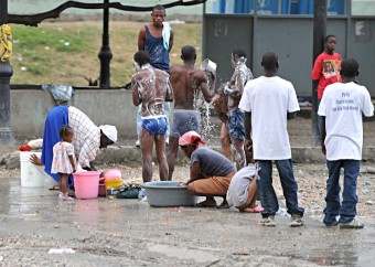 Haitianos tomam banho em campo de refugiados | IKMR