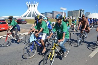 Com a Catedral de Brasília ao fundo e usando a camiseta promocional do ACNUR, refugiados participam de passeio ciclístico que celebrou antecipadamente o Dia Mundial do Refugiado.