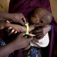 Uma funcionária do ACNUR da comunidade mede o pulso de um bebê de oito meses no campo de refugiados Ifo em Dadaab, no Quênia, ano passado.