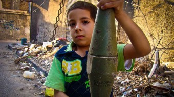 Menino sírio segura morteiro intacto e supostamente disparado por tropas governamentais - Lens Young Homsi‎