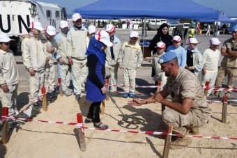 Integrante da força de paz da ONU mostra para alunos de escola como manejar um detector de minas terrestres, que ficam sob a areia Foto:  Reuters