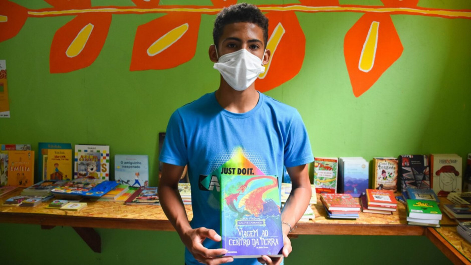 O jovem Israel diz que lerá o livro “Viagem ao Centro da Terra” aos irmão mais novos. © ACNUR/Camila Ignacio Geraldo