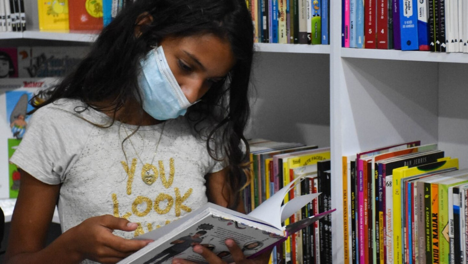Leli, de 12 anos, lê livros em português e espanhol na biblioteca do Abrigo Rondon 1. © ACNUR/Camila Ignacio Geraldo
