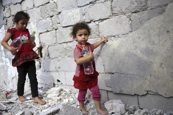 Duas irmãs carregam água potável para a casa em que vivem no barrio de Shuja'iyya em Gaza
